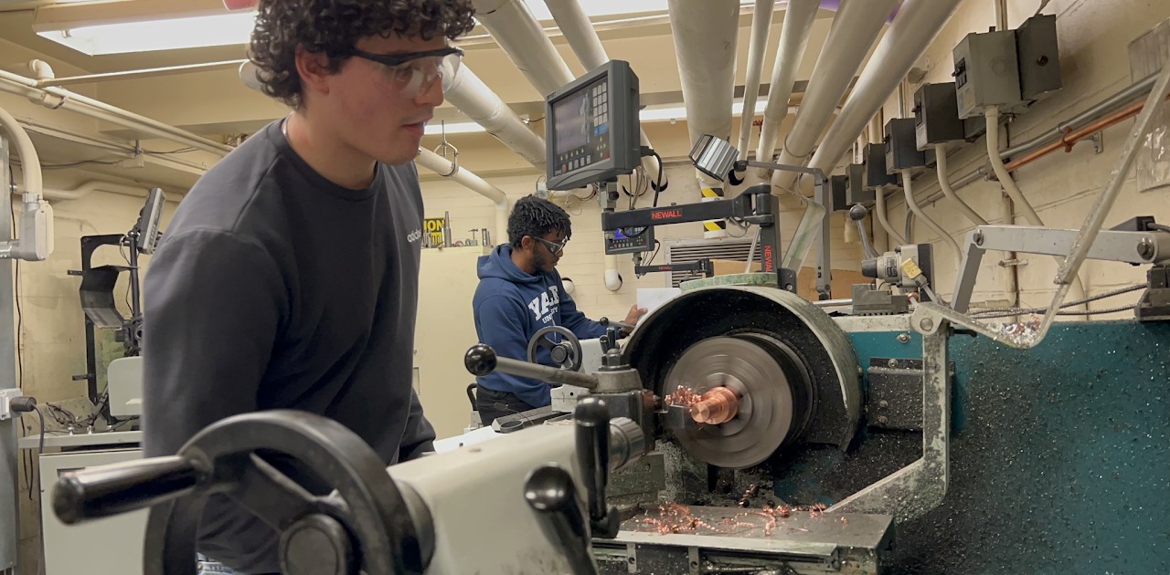 My subteam lead (in blue) and I (in black) machining ASIs on the lathe